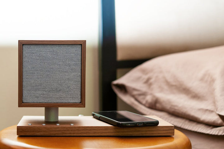 front view on walnut tivoli audio revive with an iPhone charging 
