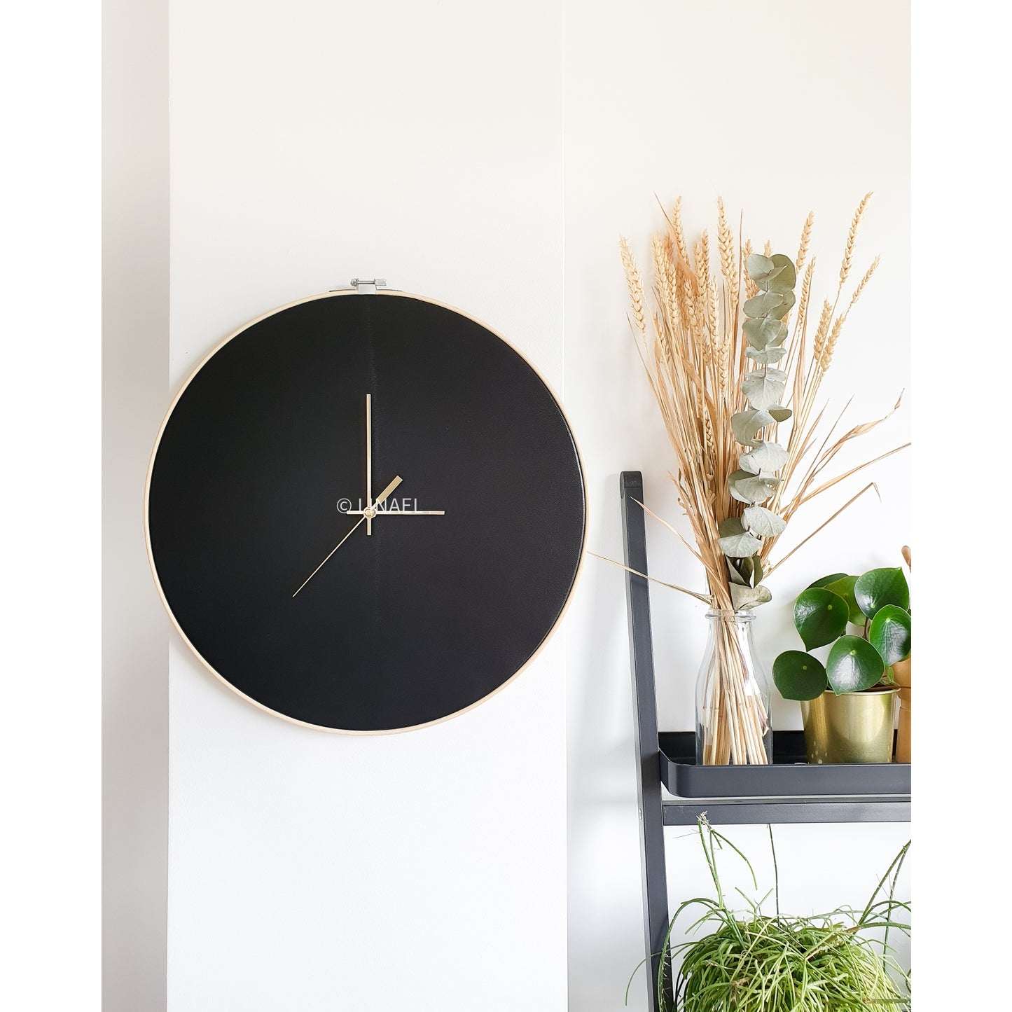 large wall clock in black on white wall