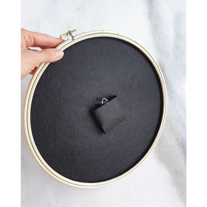 rear of black lineal clock being held by a male