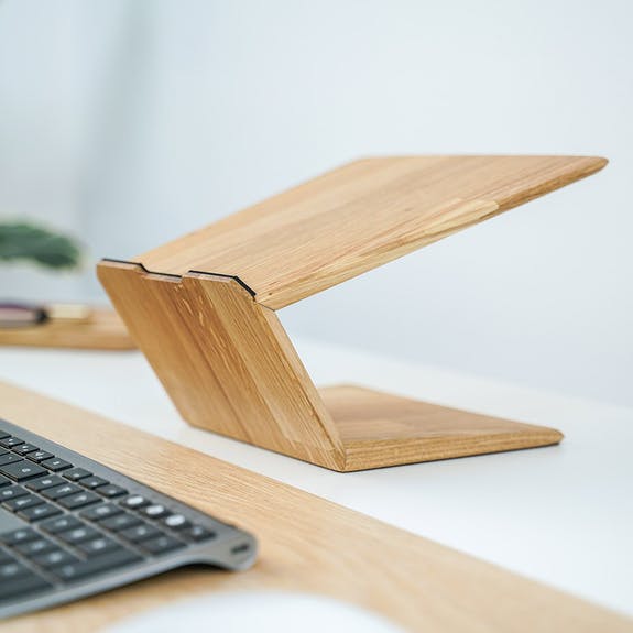 Oak laptop riser stand on white office desk 