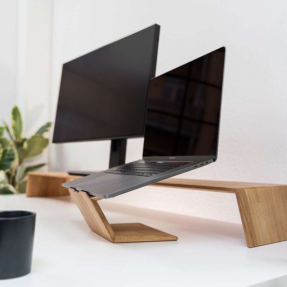 laptop riser stand next to a monitor riser on a white desk