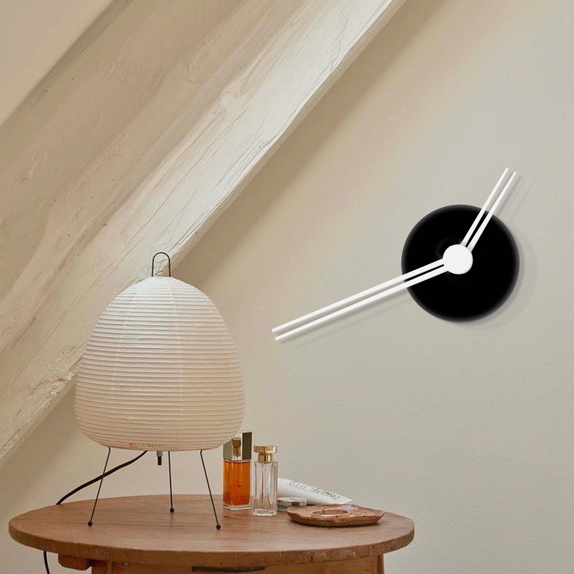 Capriccio wall clock next to a lamp against a beige wall