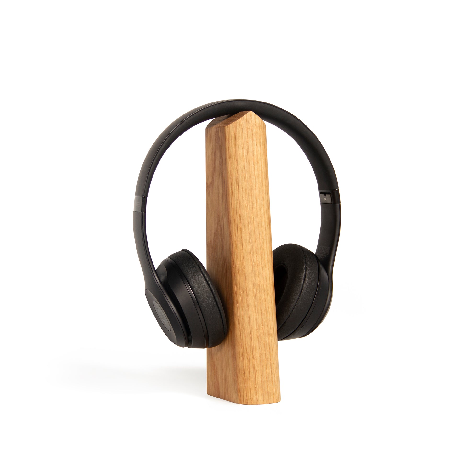 Woodendot Headphone stand in oak with headphones on top against a white background