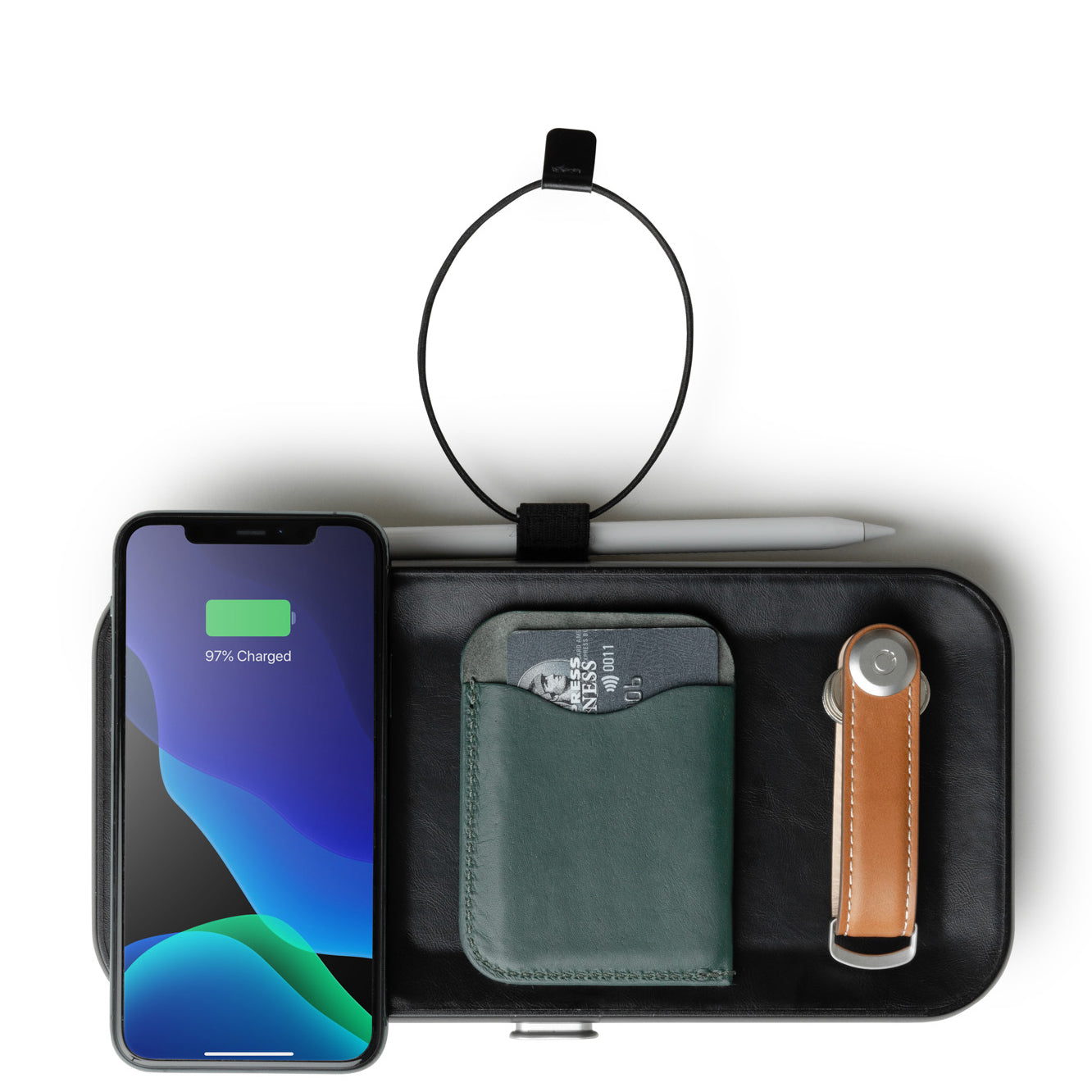 the nest with an iPhone on top charging next to a wallet and set of keys 