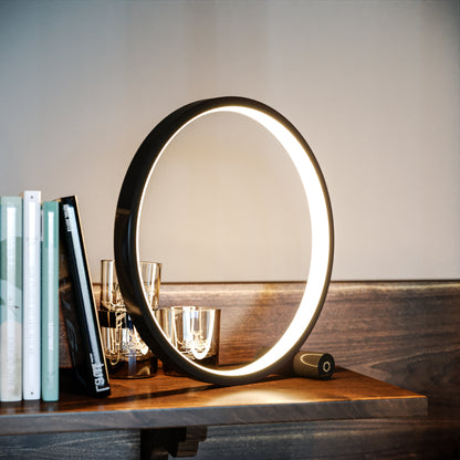 Heng circle light on wooden desk next to some books
