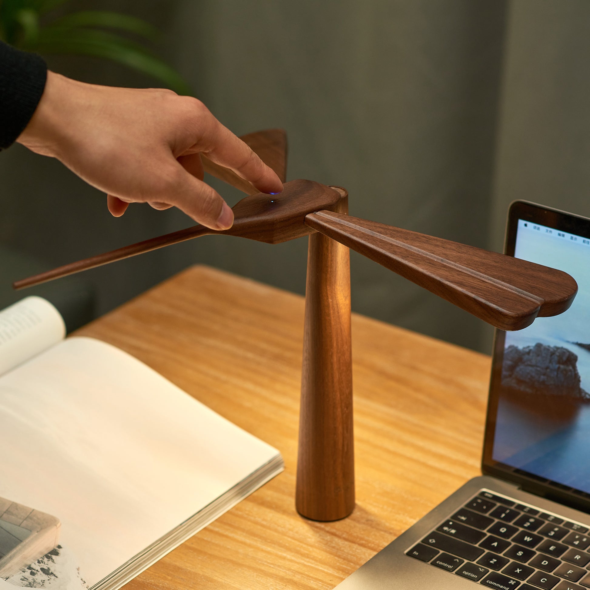 dragon flight lamp by gingko on wooden desk next to macbook
