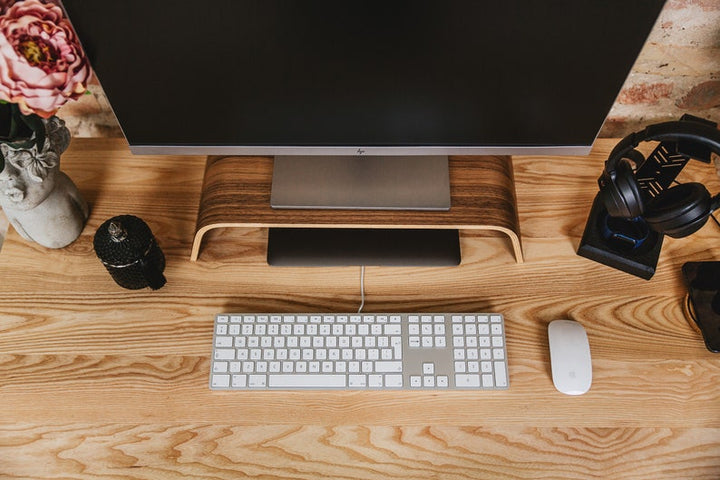 top down view of Halostands monitor and headphone holder next to apple keyboard