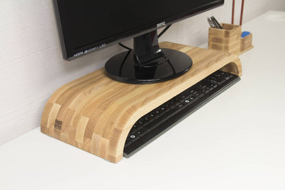 wood monitor riser on a white desk with a screen on top