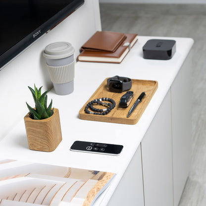oak planter alongside apple tv and accessories on a white desk