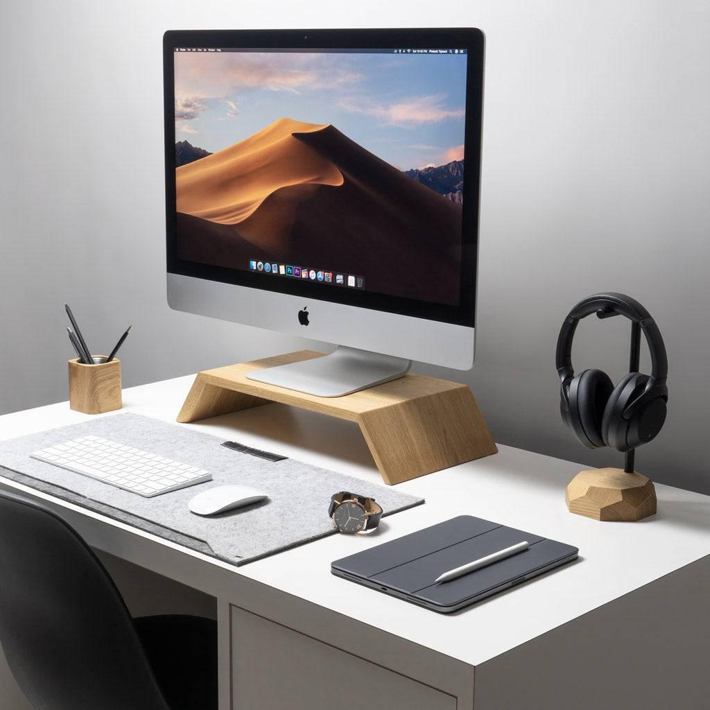 Oakywood monitor riser on white desk with iMac on top.