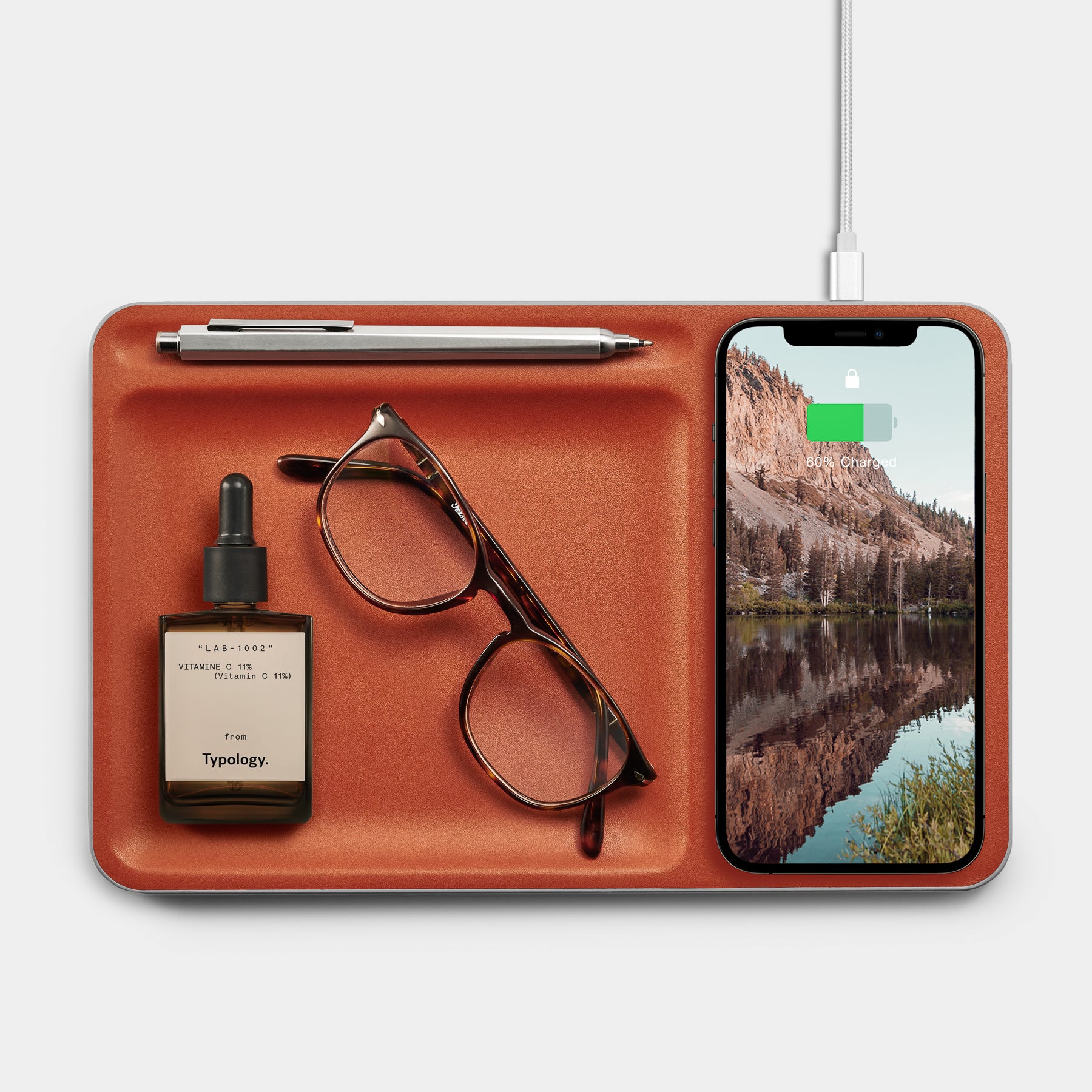 Cognac Leather charging station with iphone and glasses over white background