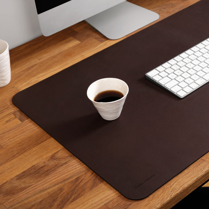 close up of carl friedrik desk mat with coffee cup on top of it