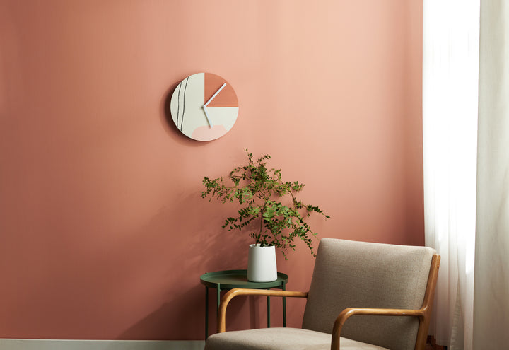 hand painted wall clock on burnt orange walk in front of a desk chair