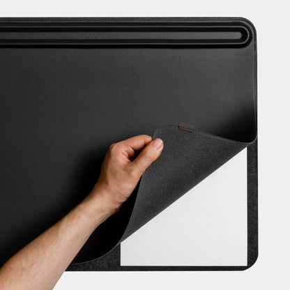 male lifting the orbitkey desk mat up revealing a layer for spare notes