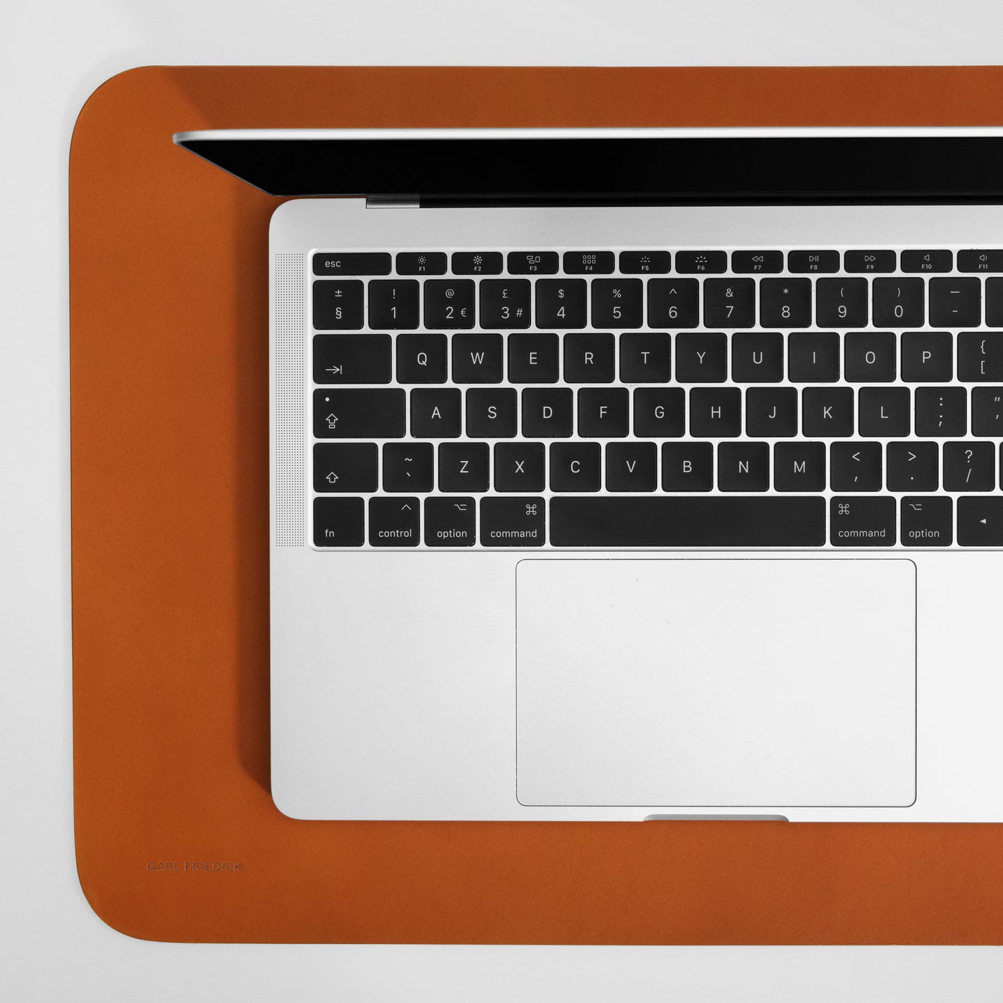 close up of cognac leather desk mat underneath an apple MacBook pro