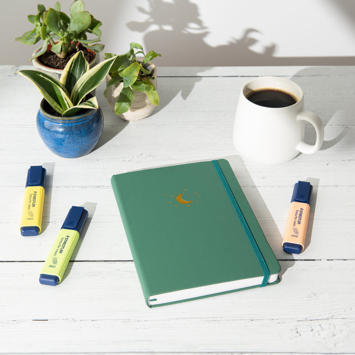 yop and tom lined notebook on a desk next to a cup of coffee