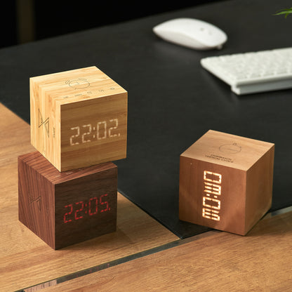 Selection of three gingko cube plus clocks on a wooden desk