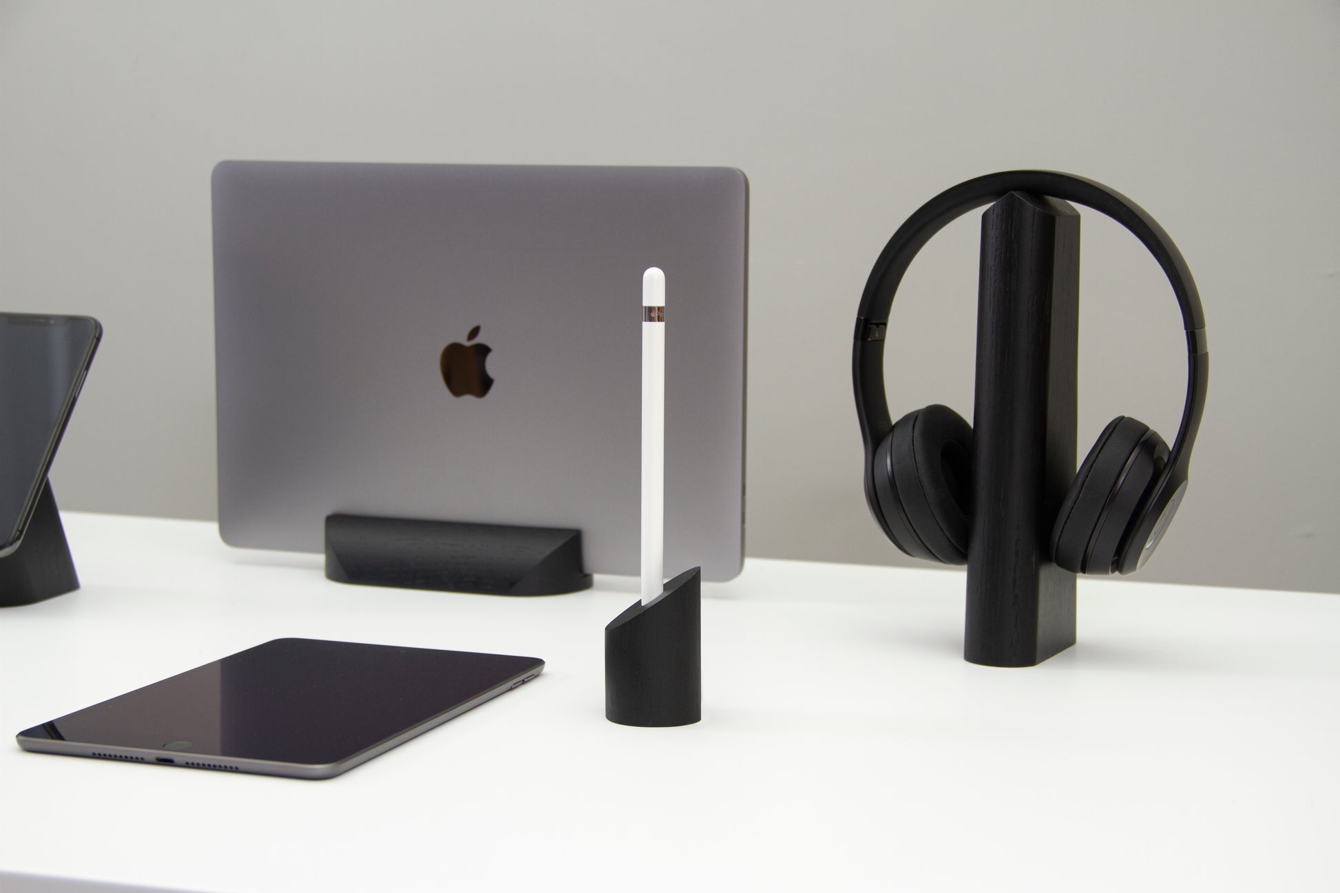 sima Apple Pencil holder on a white home office desk next to a MacBook pro